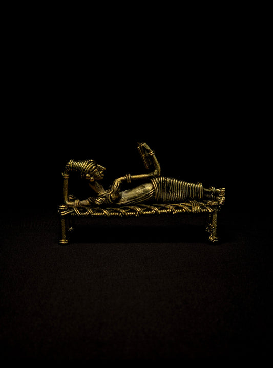 Dhokra - Tribal Lady sleeping on bed and reading