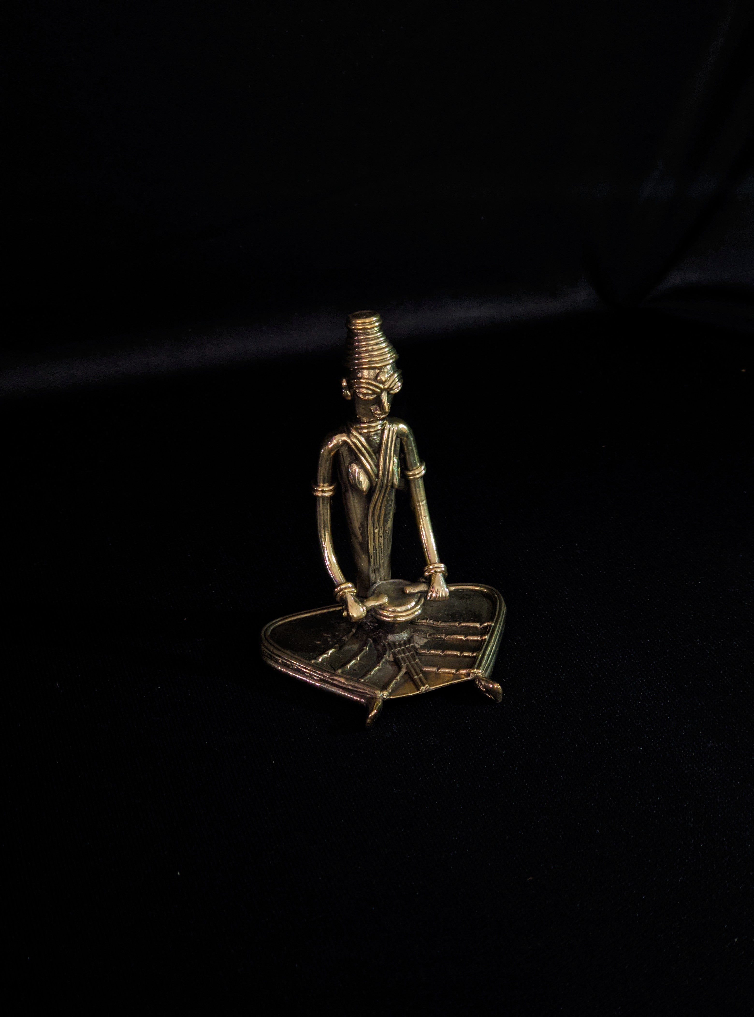 Dhokra - Tribal Lady musician sitting and playing Drum