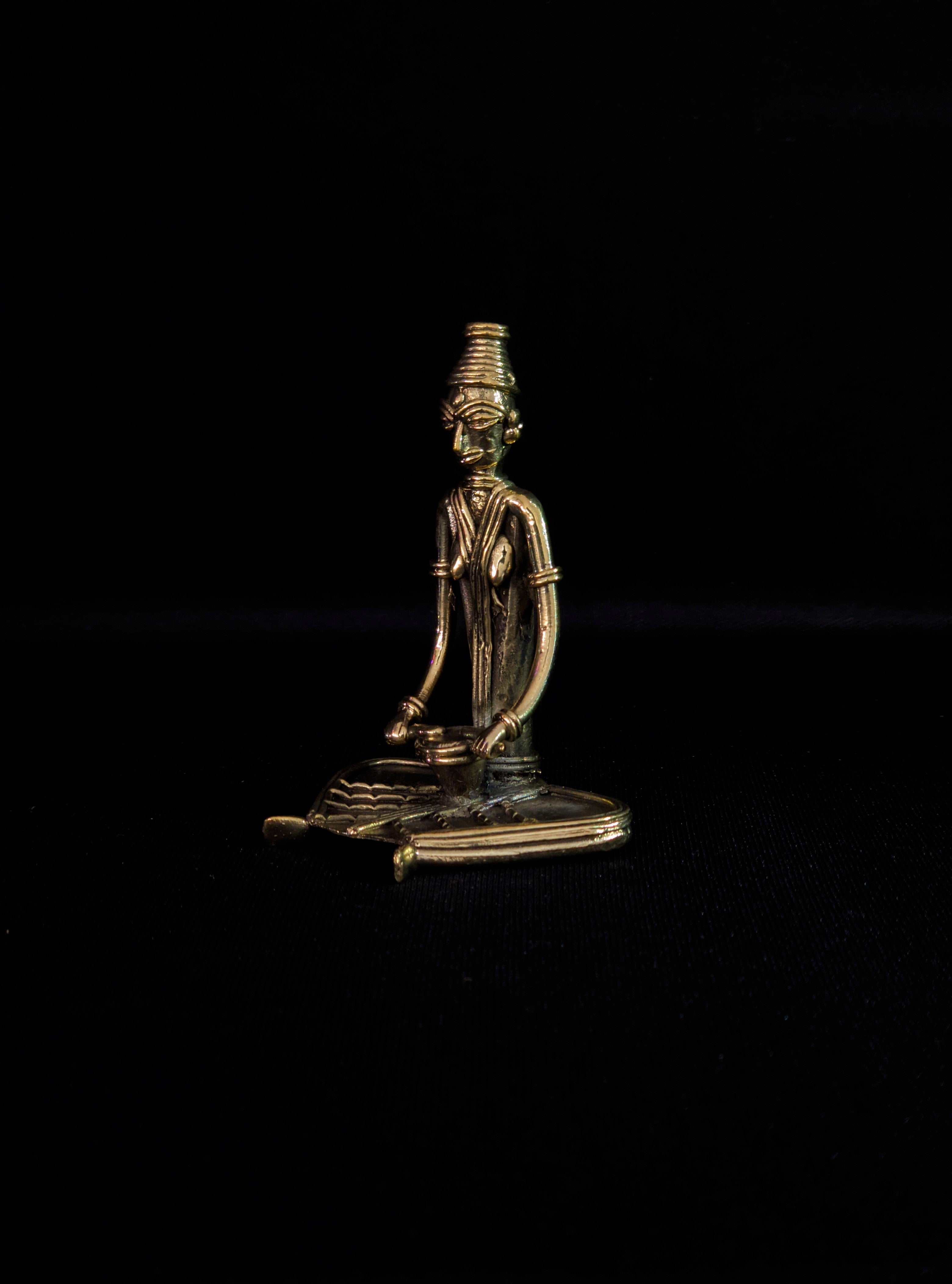 Dhokra - Tribal Lady musician sitting and playing Drum